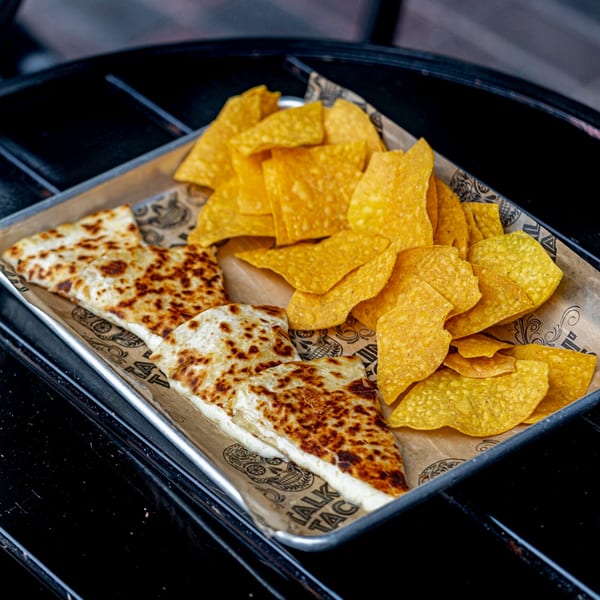 Talkin' Tacos quesadillas and tortilla chips served on a metal tray with branded paper.