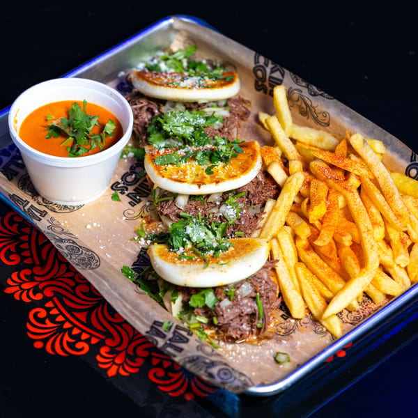 Four Talkin' Tacos birria tacos with a side of fries and a cup of consommé.